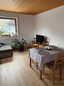 a living room with a table and a chair at Ferienwohnung Landleben in Bühlertann