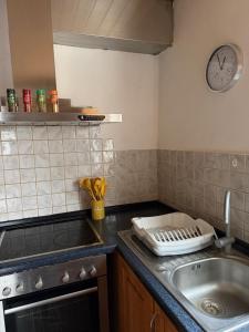 a kitchen with a sink and a clock on the wall at Ferienwohnung Landleben in Bühlertann +17 photos