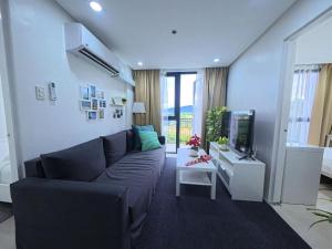 a living room with a couch and a tv at Unit 509 - One Pontefino Tower in Batangas City