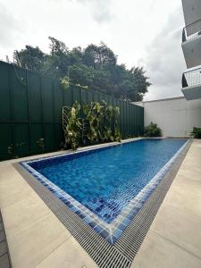 a swimming pool in a backyard with a fence at Unit 509 - One Pontefino Tower in Batangas City