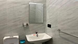 a bathroom with a sink and a toilet and a mirror at Breezy Resort in Arugam Bay