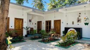 a white building with plants in the courtyard at Breezy Resort in Arugam Bay