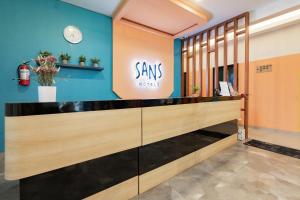 a dressing room with a smileys sign on the wall at Sans Hotel Elrose Place in Samarinda