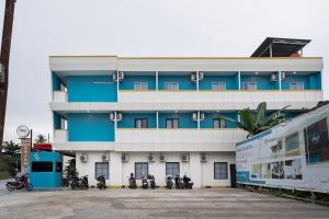 a building with motorcycles parked in front of it at Sans Hotel Elrose Place in Samarinda