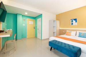a bedroom with a large bed and a desk at Sans Hotel Elrose Place in Samarinda +37 photos