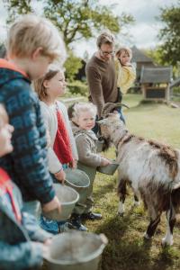 a group of children and adults standing around a goat at Landhoeve in Oosterwolde