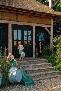 a child standing on the front porch of a house at Landhoeve in Oosterwolde +20 photos