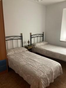 two beds sitting next to each other in a room at Liencres Apartment in Liencres