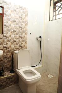 a bathroom with a white toilet and a shower at PALISADES homes in Voi