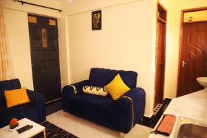 a living room with a blue couch and yellow pillows at PALISADES homes in Voi