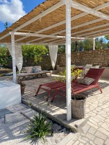 a wooden pergola with two chairs and a table at Casa vacanze Madre Terra in Putignano