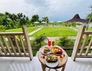 a plate of food on a table on a porch at Ratna's Green Hill Penida by Bali Cabin in Nusa Penida