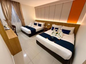 a hotel room with two beds with shoes on them at City Central Hotel in Kuala Lumpur