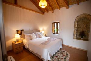 a bedroom with a white bed and a window at Armonia Sun Tower in Exochori