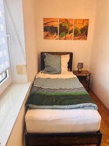 a bed in a room with two paintings on the wall at Charmantes Apartment Roding mit 3 Schlafzimmer in Roding