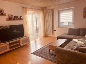 a living room with a couch and a flat screen tv at Charmantes Apartment Roding mit 3 Schlafzimmer in Roding
