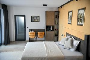 a bedroom with a bed and a kitchen with orange chairs at Villa Alveare in Banya