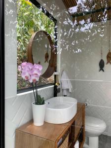 a bathroom with a sink and a mirror and flowers at La Loma in La Vega