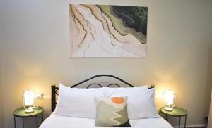 a bedroom with a bed with two lamps on both sides at Khwanlom House in Lampang