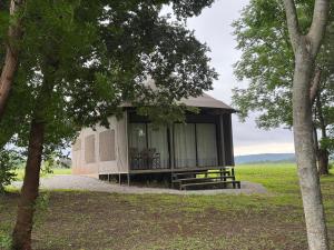 a cabin in the middle of a field with trees at Jacil Riverside Accommodation in Hekpoort +11 photos