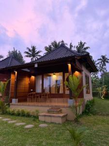 a small house with a patio in the yard at Wana Ayu Jelijih Villas by Dhananjaya Hospitality in Tampaksiring