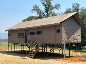 a large tent with a ladder in a field at Jacil Riverside Accommodation in Hekpoort