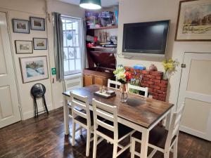 a dining room with a table and chairs and a television at Canterbury within the city wall - Sleeps 7 - Pet-Friendly with Garden in Canterbury