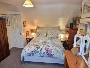 a bedroom with a bed with a floral bedspread at Canterbury within the city wall - Sleeps 7 - Pet-Friendly with Garden in Canterbury +8 photos