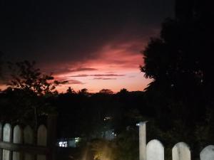 a sunset over a white fence with a white picket at Relax On Plus Kelaniya in Kelaniya