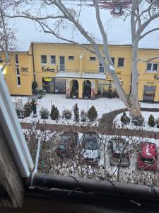a yellow building with cars parked in a parking lot at Ákos Apartman in Székesfehérvár