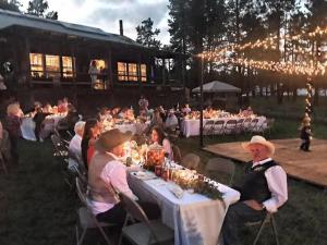 a group of people sitting at tables at a party at Beaver Creek Guest Ranch in Blue