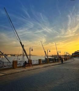a pier with a person sitting on a bench near the water at Paradise House Holiday in Luxor