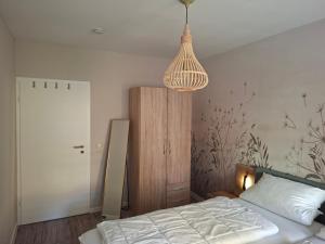a bedroom with a bed and a pendant light at Stadtrand Apartment in Markkleeberg