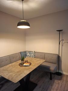 a table and a couch in a living room at Stadtrand Apartment in Markkleeberg +3 photos