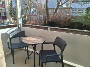 two chairs and a table on a balcony at Stadtrand Apartment in Markkleeberg