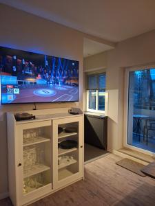 a living room with a flat screen tv on a stand at Stadtrand Apartment in Markkleeberg