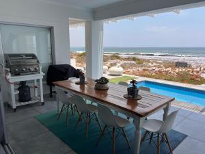 a dining room with a table and a view of the ocean at Shelley Point On Sea in St. Helena Bay