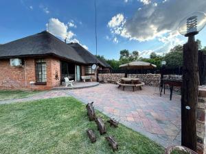 a brick house with a patio and a table at De Rust Private Nature Reserve in Odendaalsrus