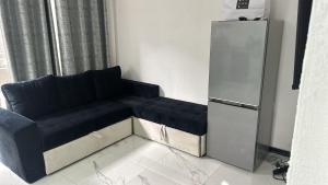 a black couch in a living room with a refrigerator at APARTMANI Sarajevo in SJJ