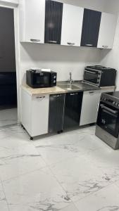 a kitchen with a sink and a microwave at APARTMANI Sarajevo in SJJ