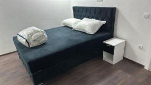 a black bed with two pillows on top of it at APARTMANI Sarajevo in SJJ