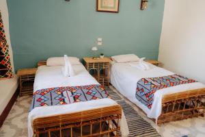 a room with two twin beds in a room at Harmonia House in Al Karnak