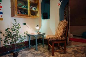 a room with a chair and a table and a lamp at Harmonia House in Al Karnak