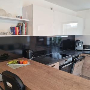 a kitchen with a table with a bowl of fruit on it at Moderne Ferienwohnung,im fränkischen Seenland , 25 min Messe Nbg in Roth +31 photos