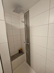 a shower with a glass door in a bathroom at Torwirt Apartments in Herrieden +24 photos