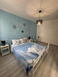 a bedroom with a bed with a blue wall at Frida Apartment in Chioggia