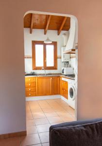 a kitchen with wooden cabinets and a washer and dryer at Casa de Madera I - Naturaleza y Experiencias in Bicorp +12 photos