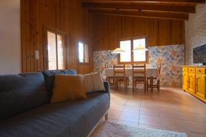 a living room with a couch and a dining room at Casa de Madera I - Naturaleza y Experiencias in Bicorp