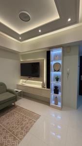 a living room with a television and a couch at One Bedroom with Balcony in Abreeza Mall in Davao City