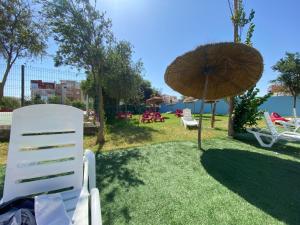 a group of chairs and an umbrella in the grass at Super Logement in Tangier